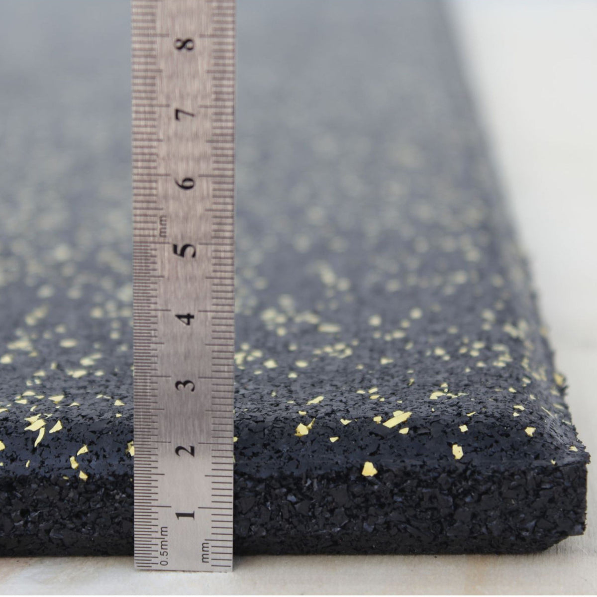 Yellow fleck rubber tile thickness shown from side