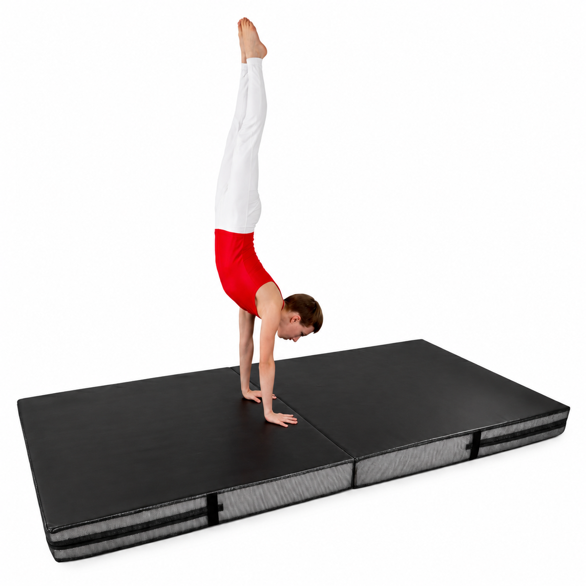 Gymnast practising a handstand on a black bi-fold crash mat.