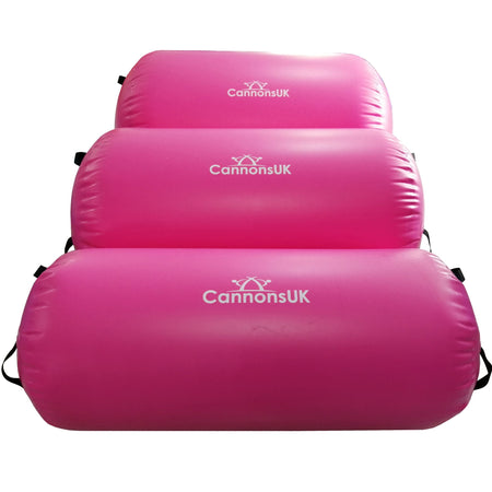 Pink inflatable bases/mats stacked flat (used with rolls); shows strap points and surface finish.