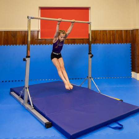Lifestyle: dismount on pink junior bar — action shot for skills practice with safety matting