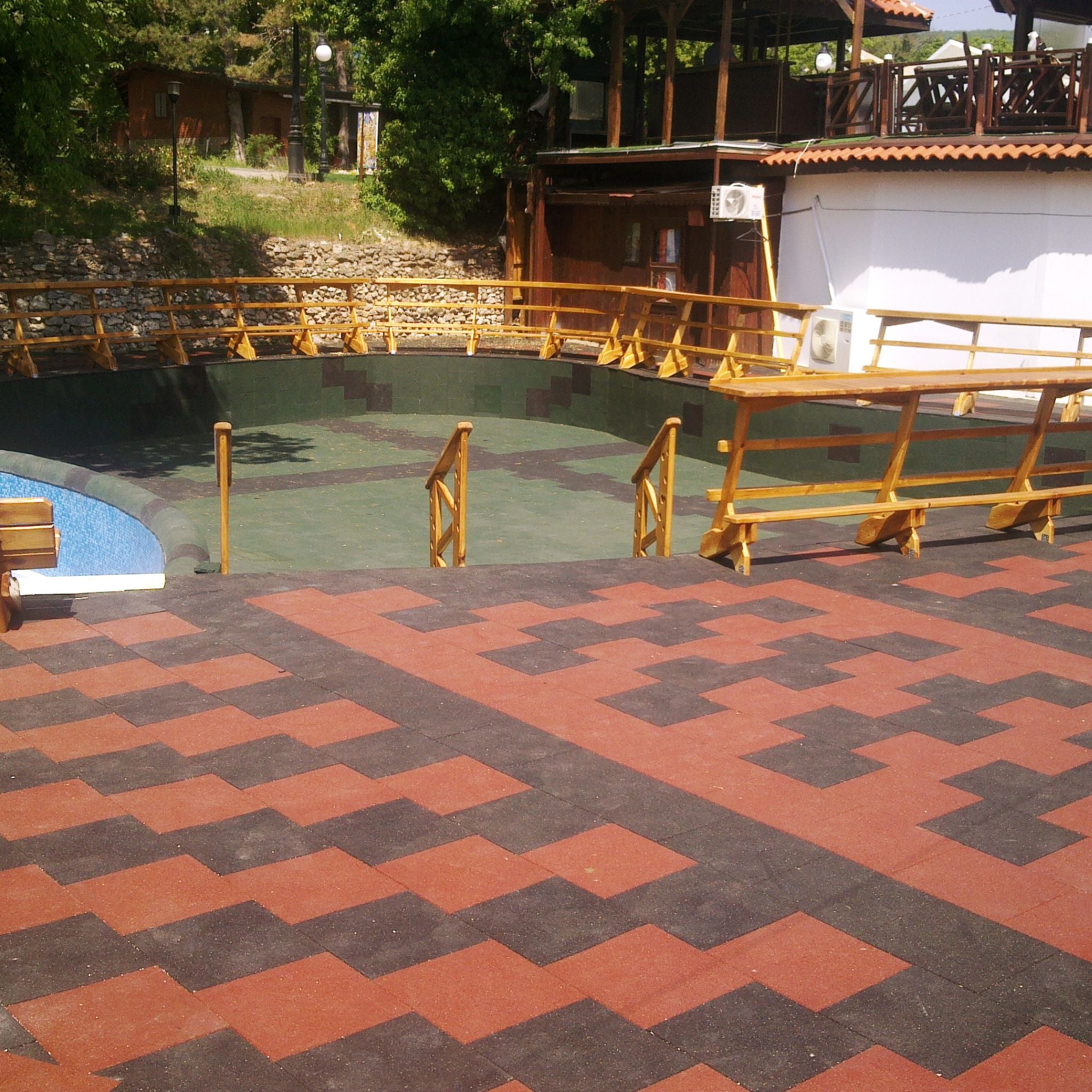 Installed red & black checker tiles — park setting, clean perimeter cuts.