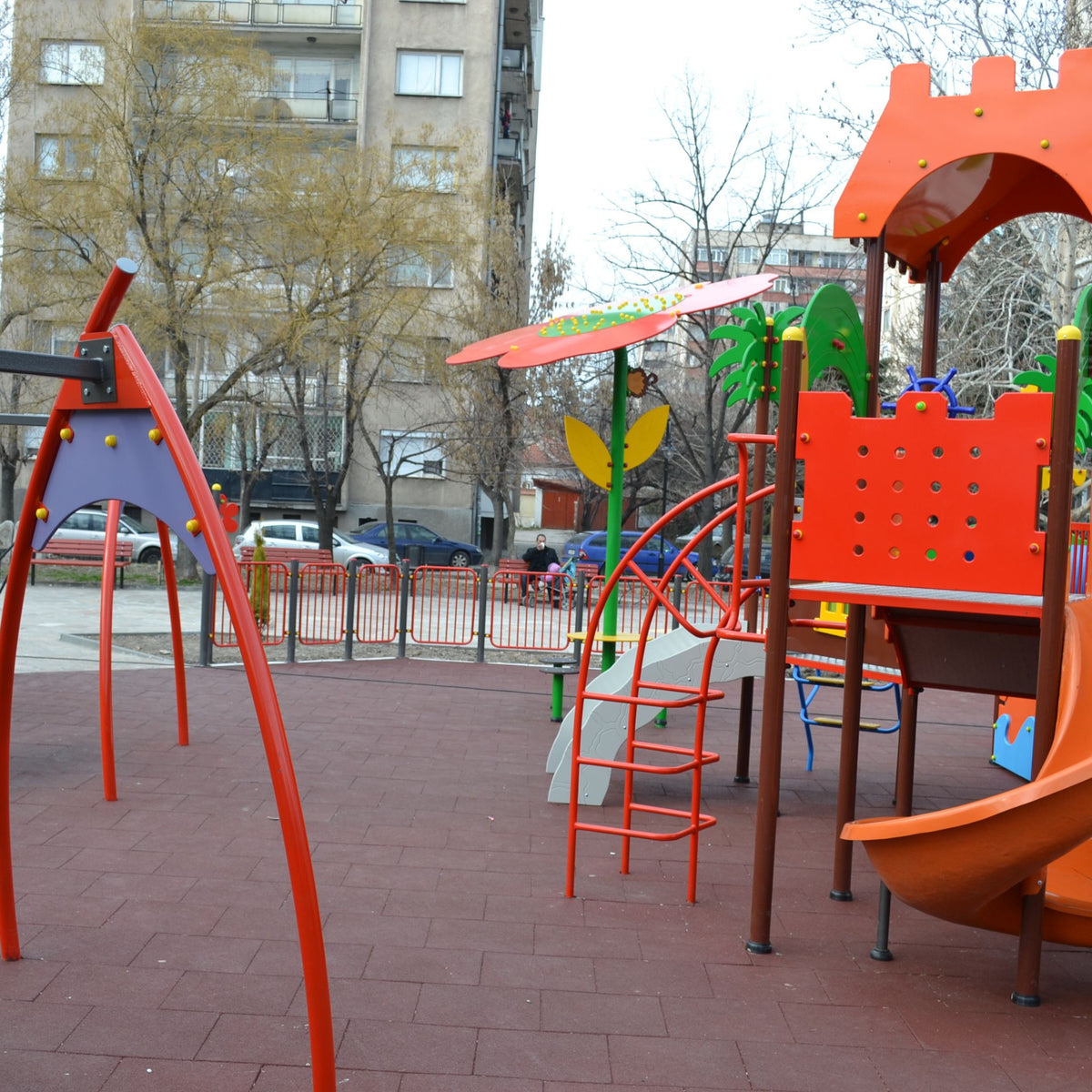 Installed red tiles — urban playground; durable, low-maintenance surface.