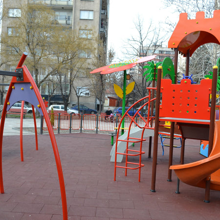 Installed red tiles — urban playground; durable, low-maintenance surface.