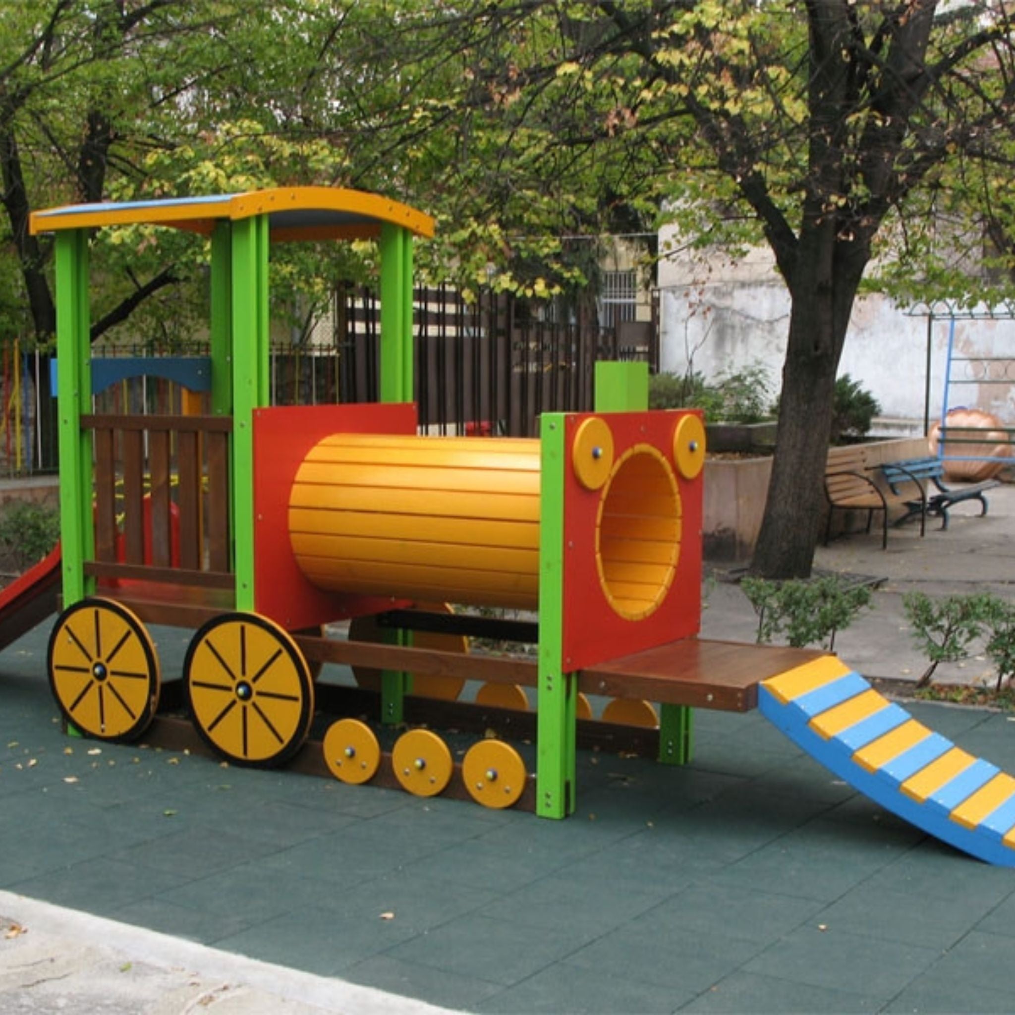 Installed green tiles — train-themed play structure on cushioned rubber.