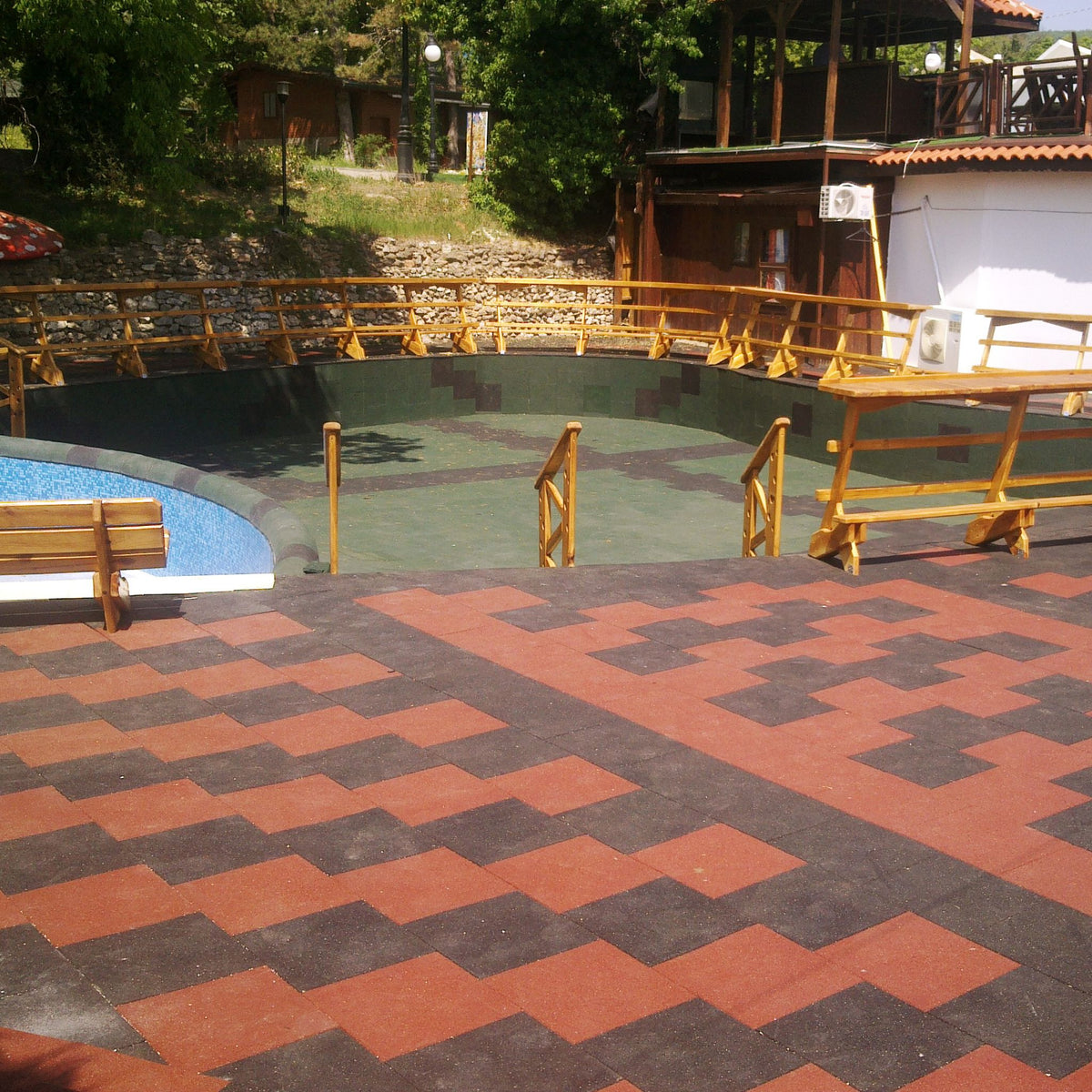 Installed red/black checker layout — wide view of shock-absorbing safety tiles.