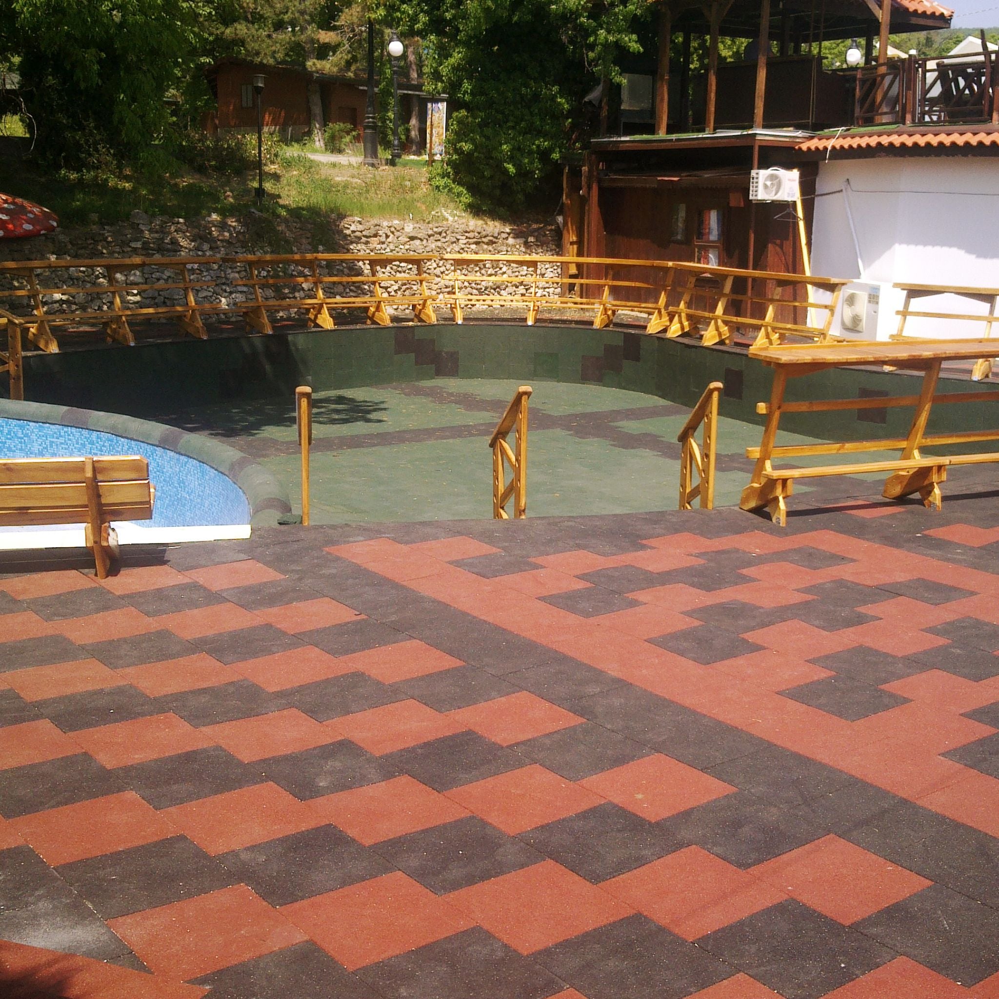 Installed red/black checker layout — wide view of shock-absorbing safety tiles.