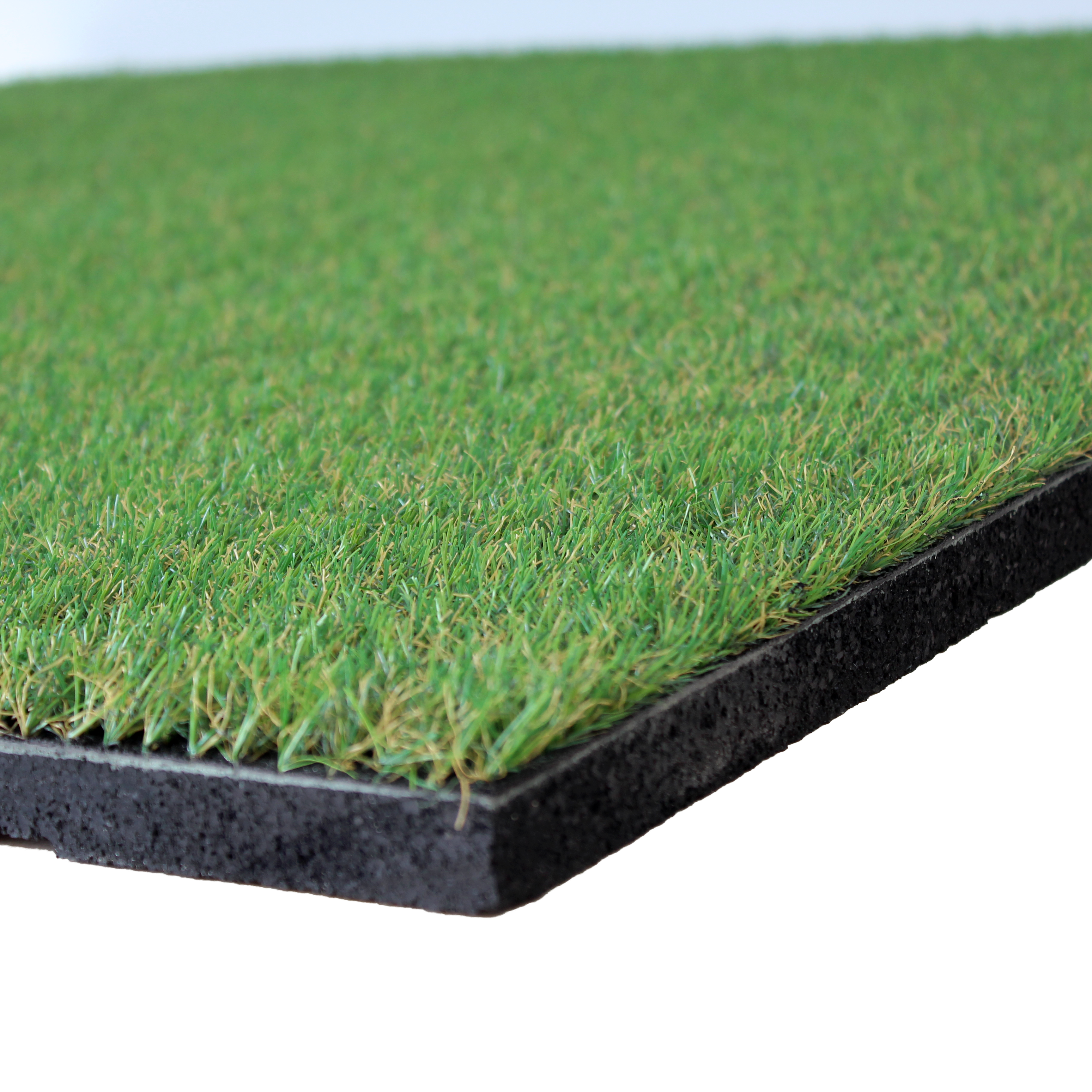 Close-up view of an artificial grass topped rubber garden floor tile, showing the textured surface of the turf and the black rubber base.