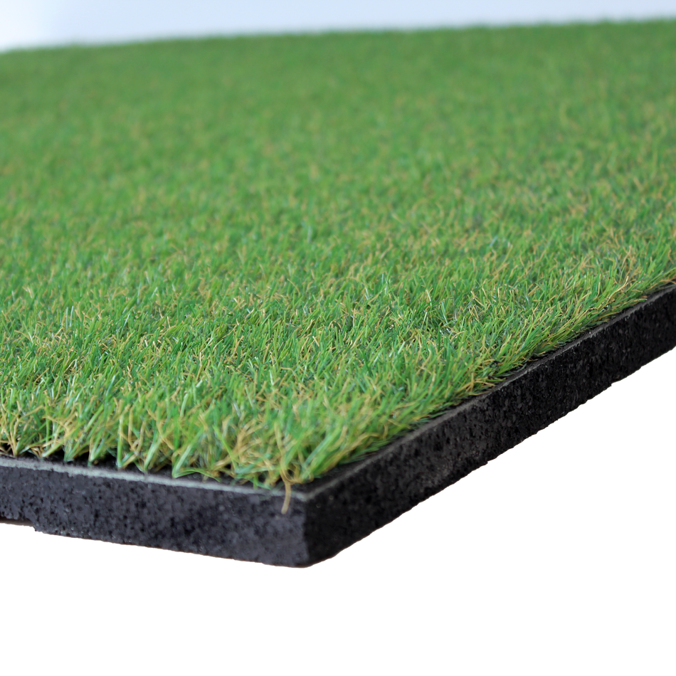 Close-up view of an artificial grass topped rubber garden floor tile, showing the textured surface of the turf and the black rubber base.