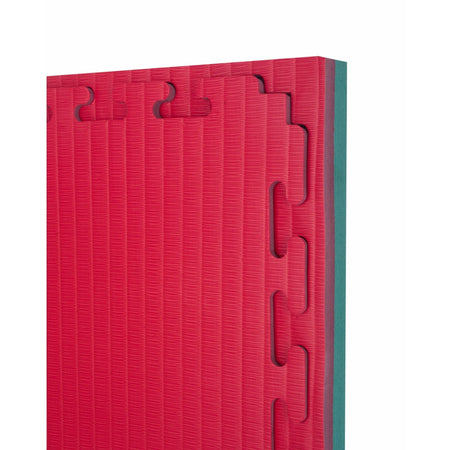 Angled stack of red and green 40 mm tatami jigsaw mats highlighting foam thickness and tatami-style textured surface.
