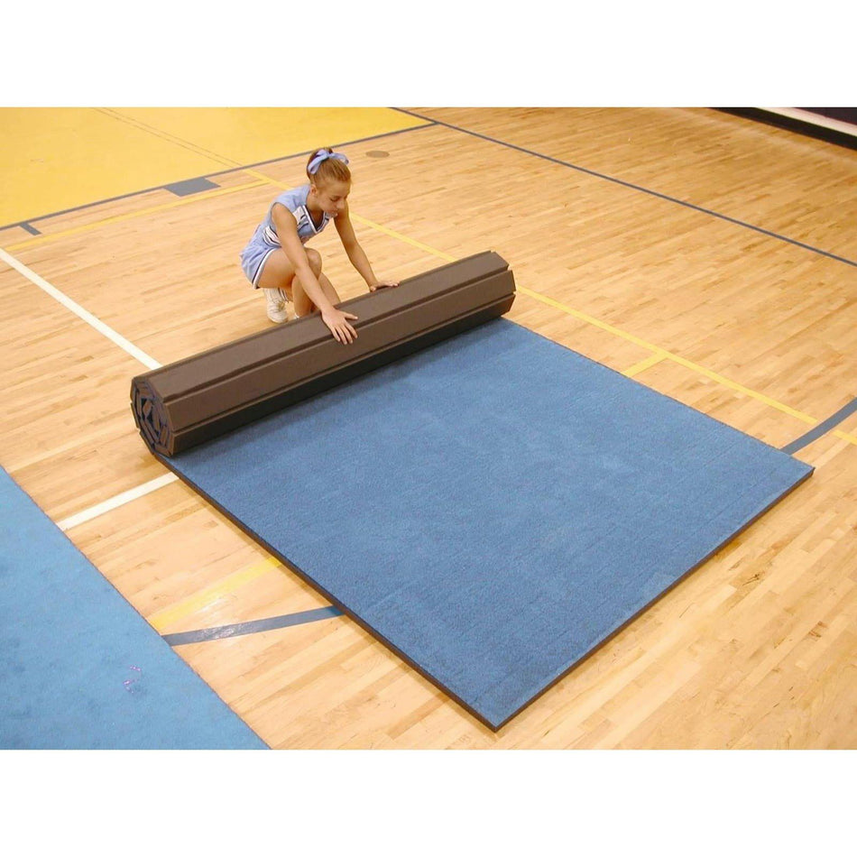 Cannons UK 6 m rollaway mat, vinyl top blue — athlete rolling the mat out on a sports court for gymnastics, wrestling and martial arts classes. 