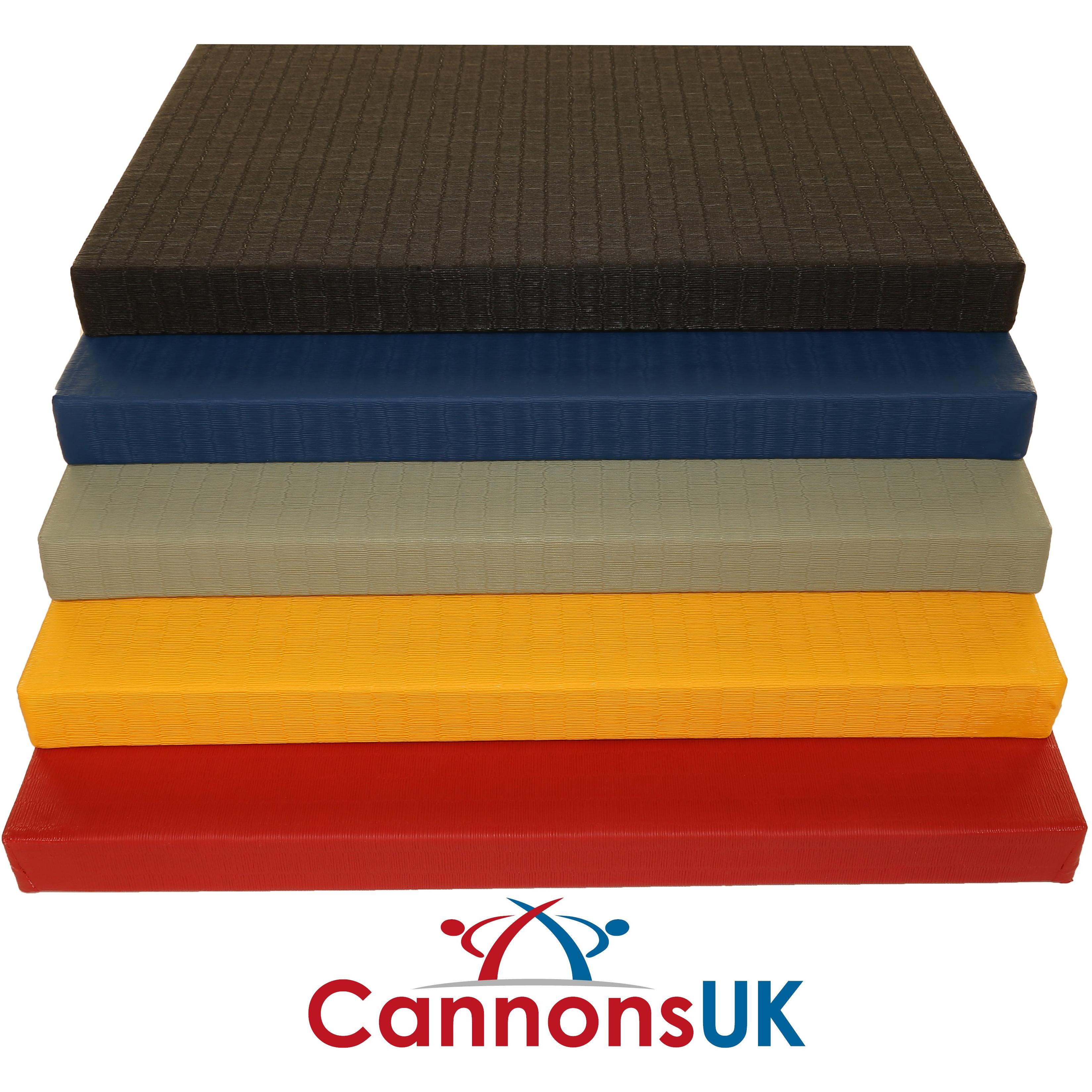 Stack of Cannons UK 1m × 1m × 40mm contest judo mats in black, blue, green, yellow and red; tatami-style textured vinyl surface for martial arts training.